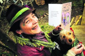 Woman smiling with book and small dog